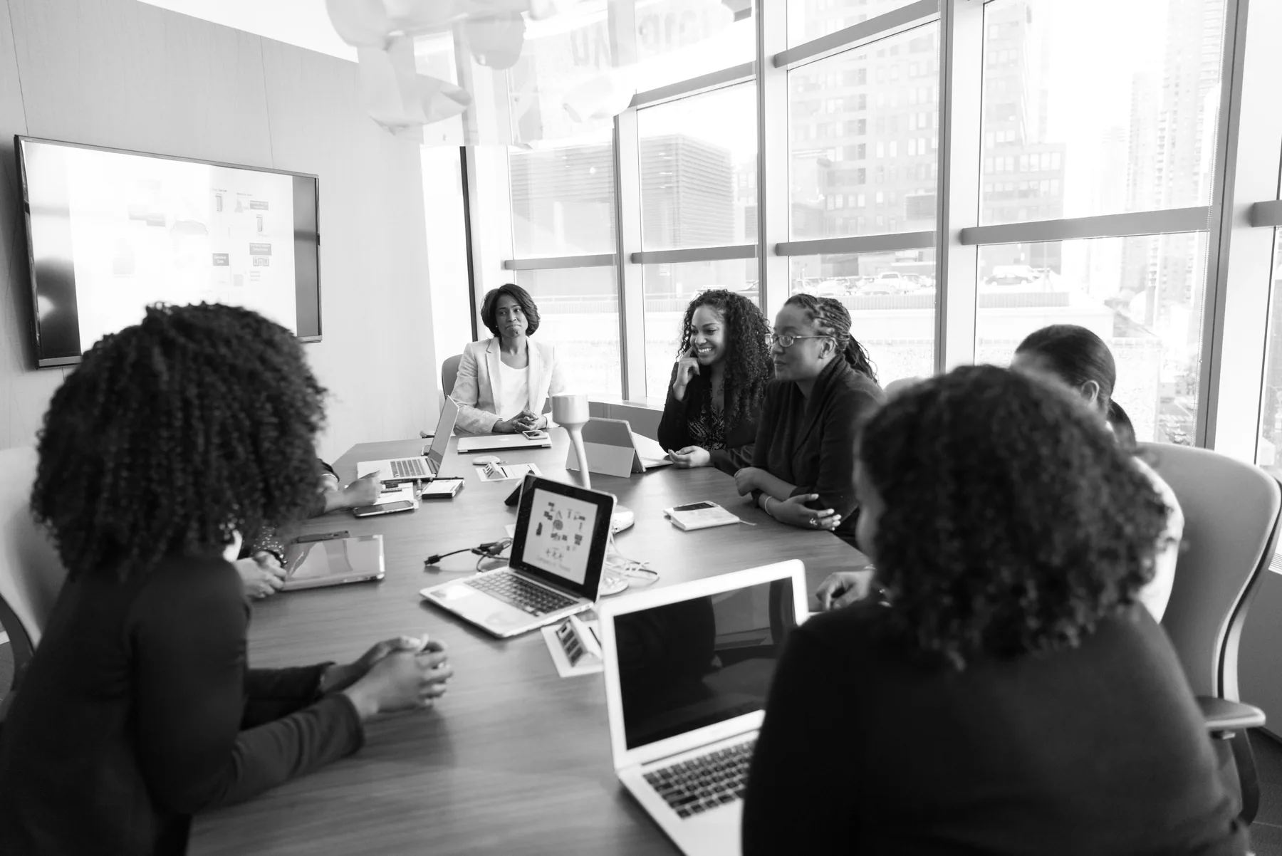 Colleagues take part in a meeting around a shared table.