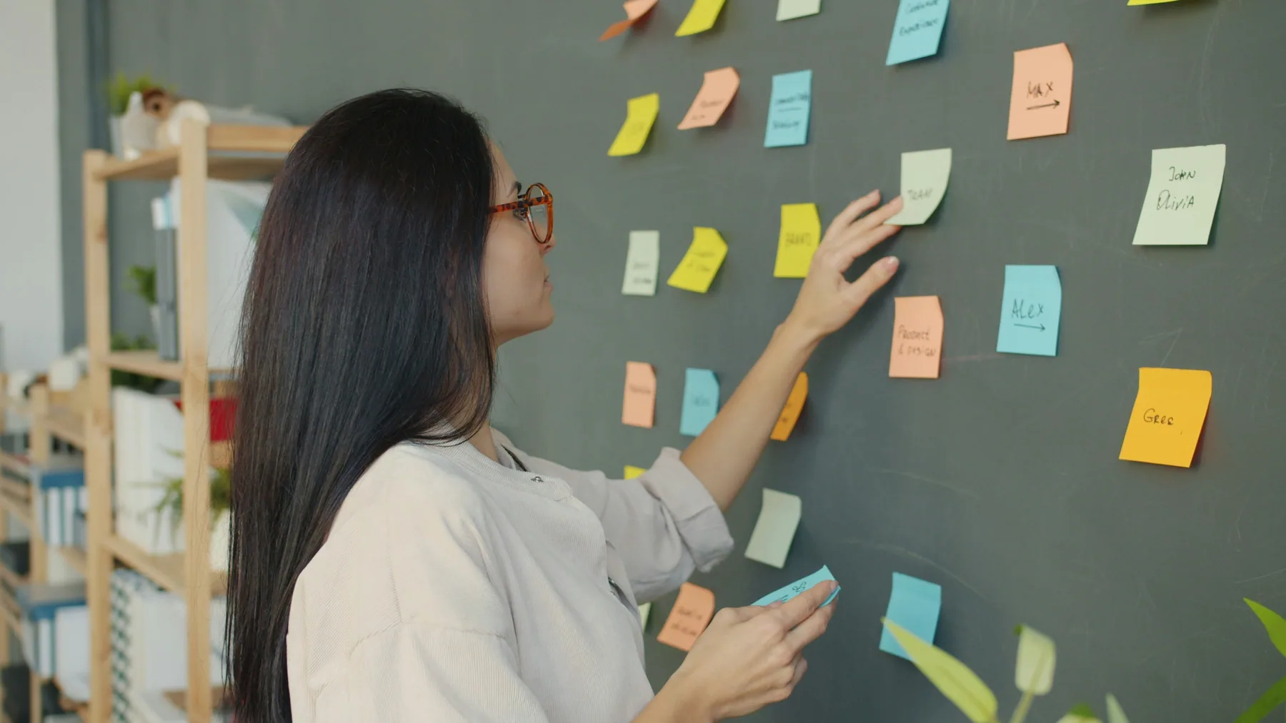 A colleague adds ideas to a shared workshop wall.